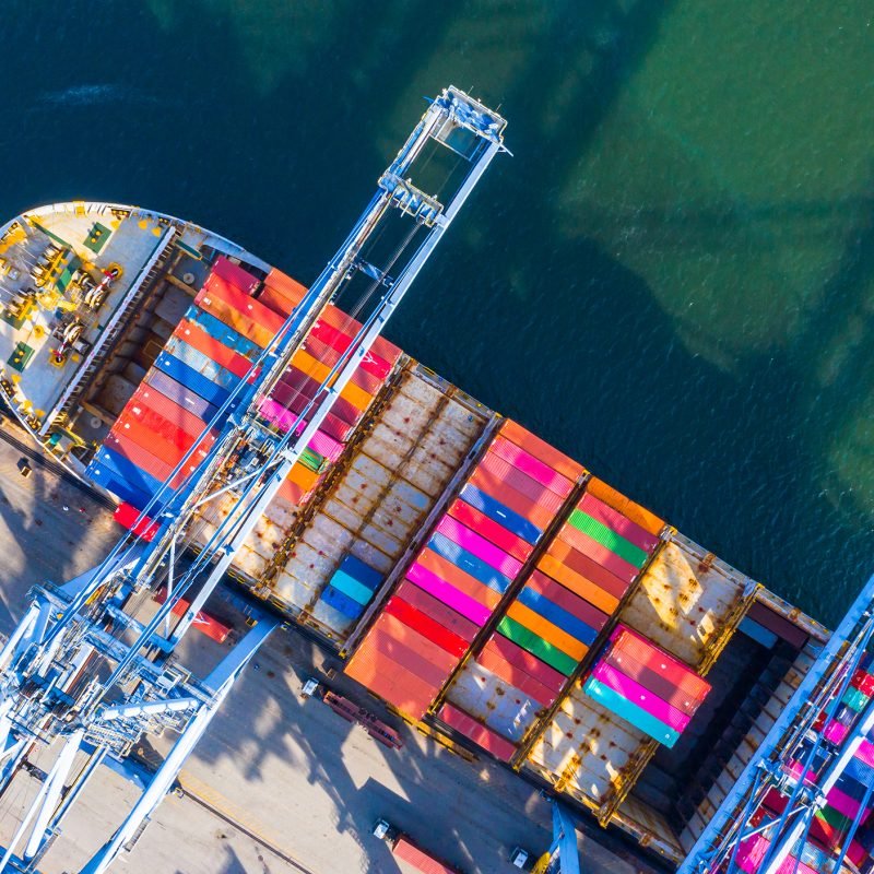 Container ship loading and unloading in deep sea port, Aerial top view of business logistic import and export freight transportation by container ship in open sea.